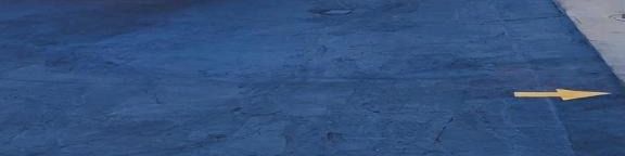 A retro motel with a blue rooftop and a small orange building, Sands Motel sign visible along a quiet street.